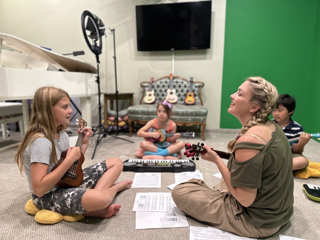 A ukulele music class with young children and woman instructor