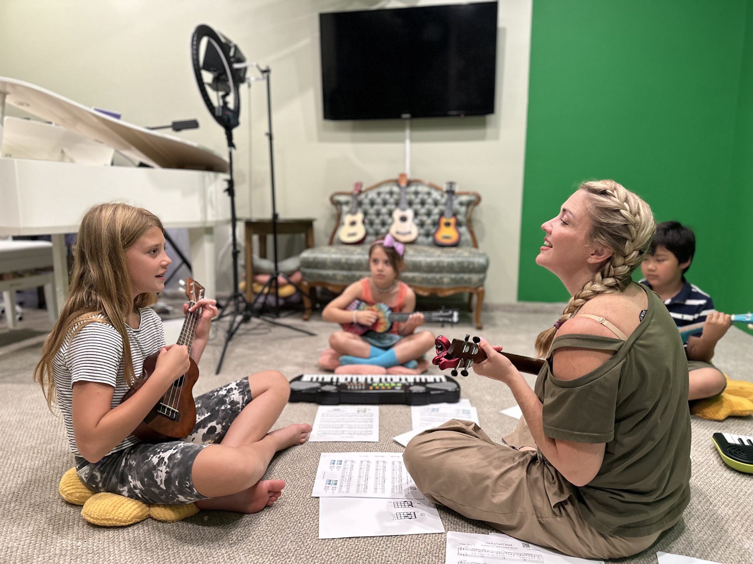 Teacher and child learning ukulele in a group class