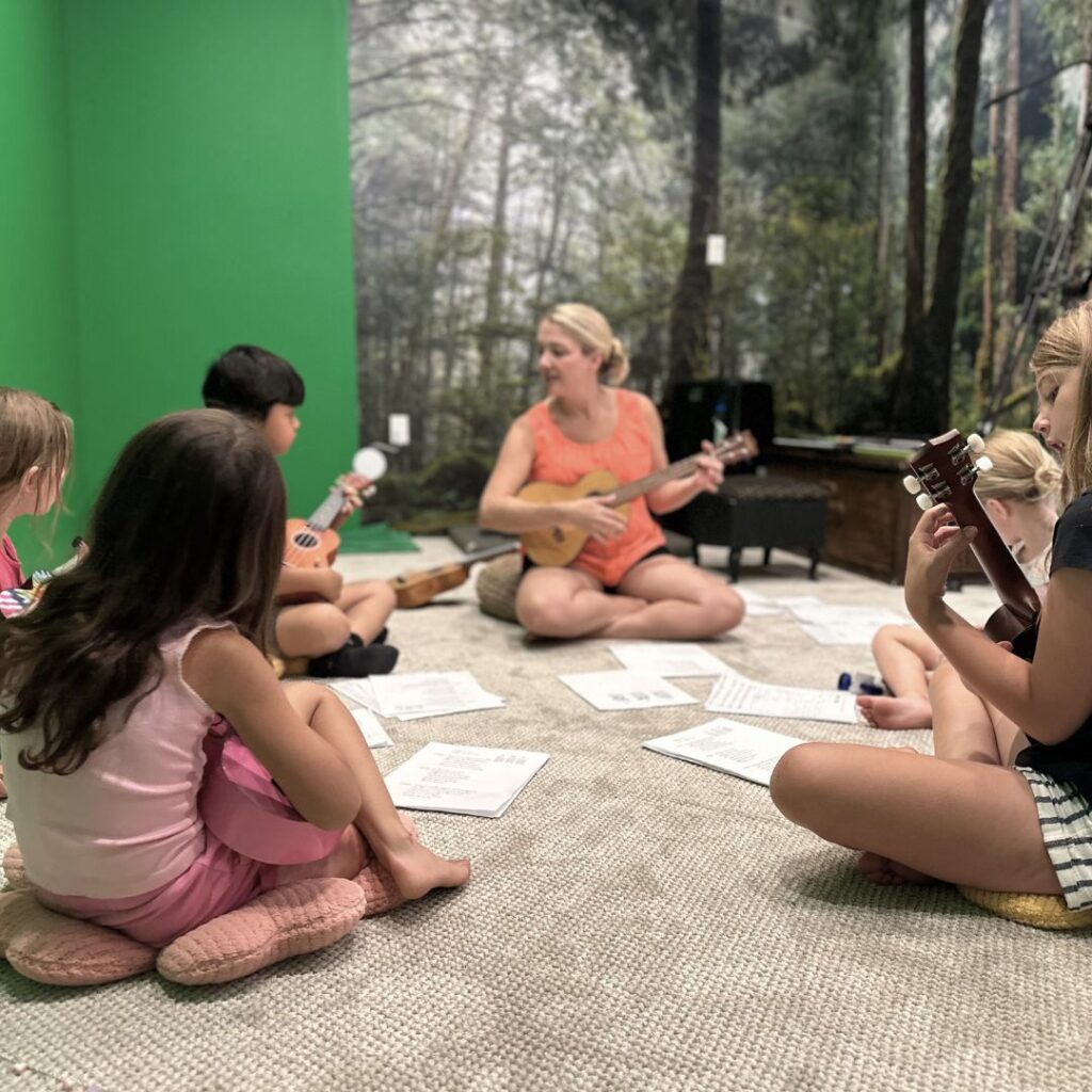 Kids sitting in a circle while learning Ukulele